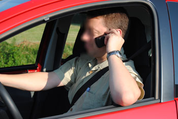 conducteur avec téléphone tenu en main.
