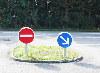 panneaux de signalisation routière sur un ilôt central.